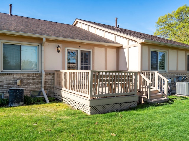 back of house featuring stucco siding, cooling unit, a wooden deck, and a yard