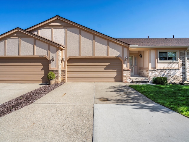 view of front facade featuring an attached garage, driveway, and brick siding