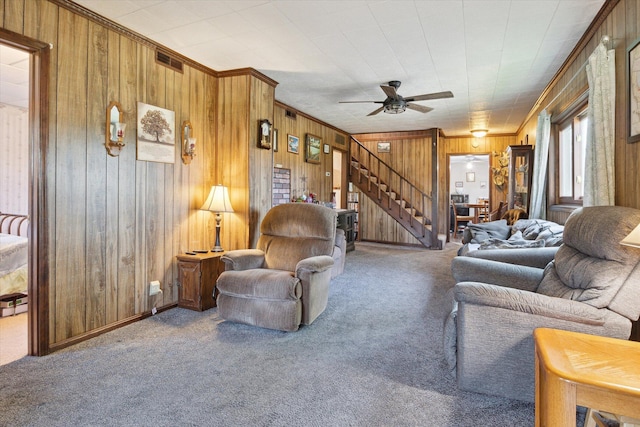 12948 Peck Ave, Sawyer, MI 49125 - living room featuring carpet, stairs, wood walls, a ceiling fan, and ornamental molding