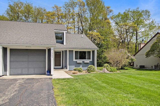 view of front of property with roof with shingles, driveway, a front lawn, and a garage
