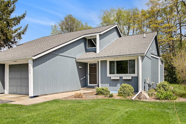 view of front facade featuring a shingled roof, a front lawn, and a garage