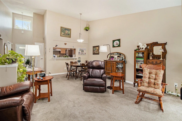 carpeted living room with a high ceiling and baseboards