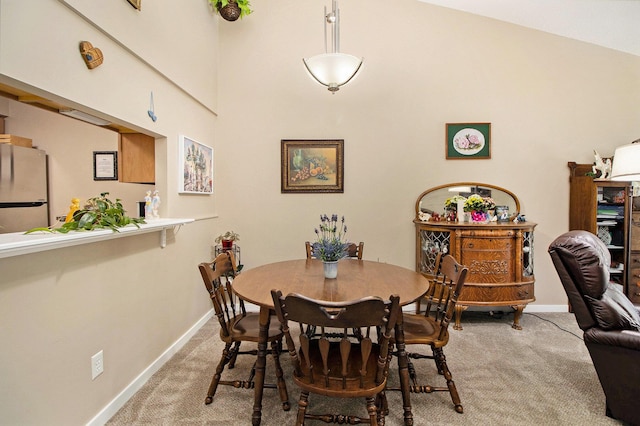 dining area featuring light carpet and baseboards