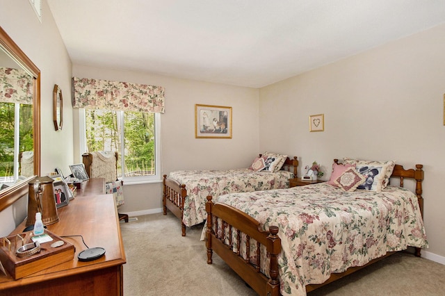 bedroom with light carpet and baseboards