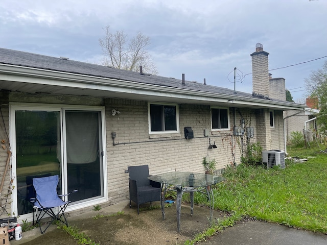 20225 Ledgestone St, Southfield, MI 48076 - rear view of property with central air condition unit, brick siding, a chimney, and a patio area