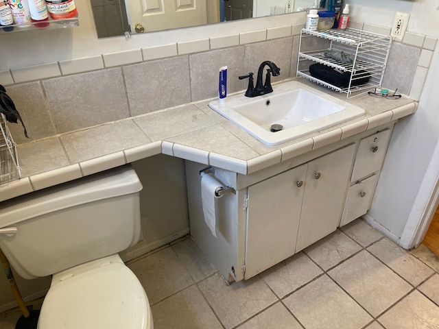 20225 Ledgestone St, Southfield, MI 48076 - half bath with vanity, tasteful backsplash, toilet, and tile patterned flooring