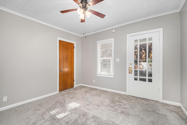 carpeted empty room with crown molding, ceiling fan, and baseboards