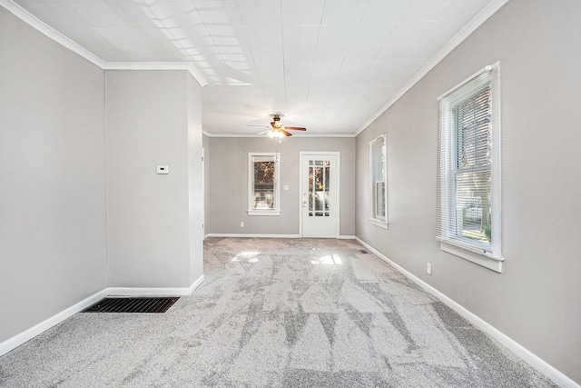 unfurnished room featuring crown molding, light carpet, a ceiling fan, and baseboards