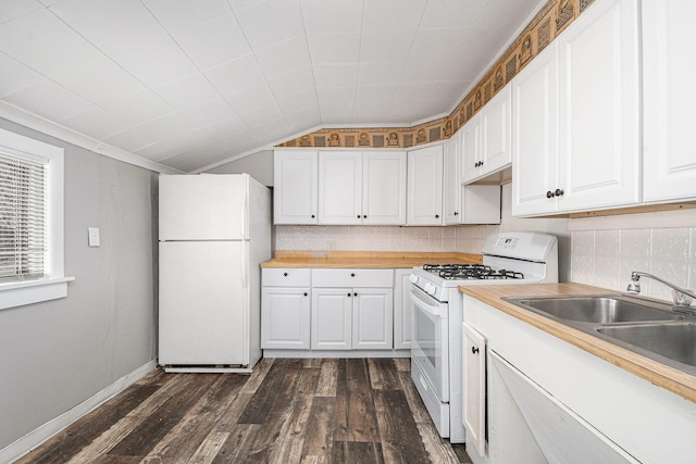 kitchen featuring white appliances, dark wood-type flooring, a sink, white cabinets, and vaulted ceiling