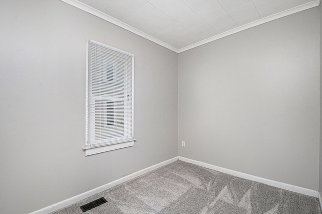 spare room with carpet, crown molding, and baseboards