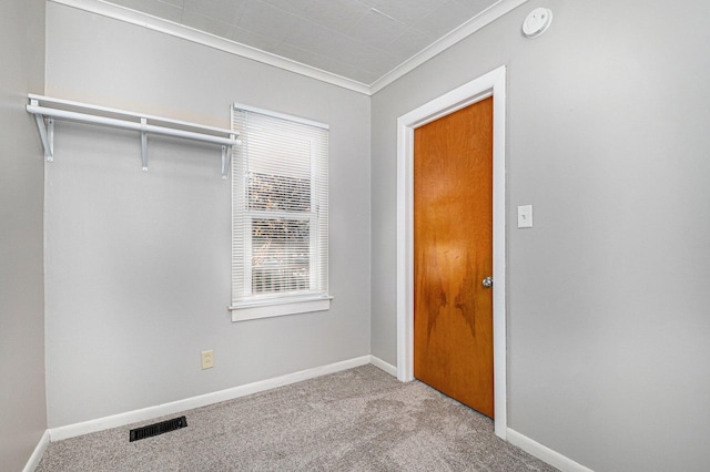 unfurnished bedroom with carpet, crown molding, and baseboards