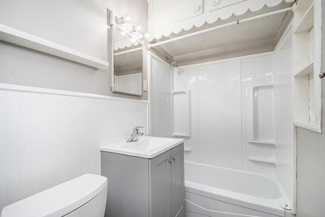 full bathroom featuring toilet, bathtub / shower combination, vanity, and wainscoting