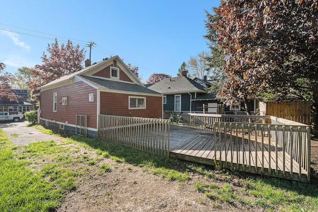 back of property featuring a wooden deck and fence