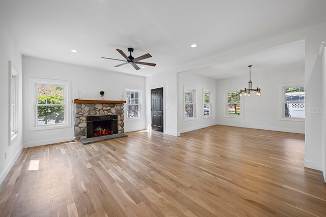 unfurnished living room with a chandelier, healthy amount of natural light, light wood finished floors, baseboards, and recessed lighting