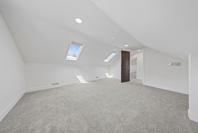 bonus room with vaulted ceiling, light colored carpet, a skylight, recessed lighting, and baseboards