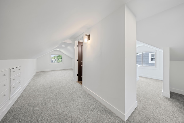 additional living space featuring carpet, lofted ceiling, and baseboards