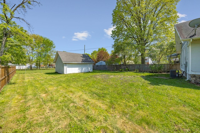 view of yard with central AC and a detached garage