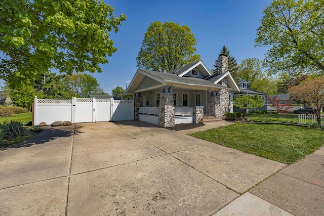 view of front facade with a gate, covered porch, stone siding, and a chimney