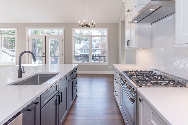 5535 W Huron River Dr, Dexter, MI 48130 - kitchen with stainless steel range, a sink, wall chimney exhaust hood, backsplash, and dark wood finished floors