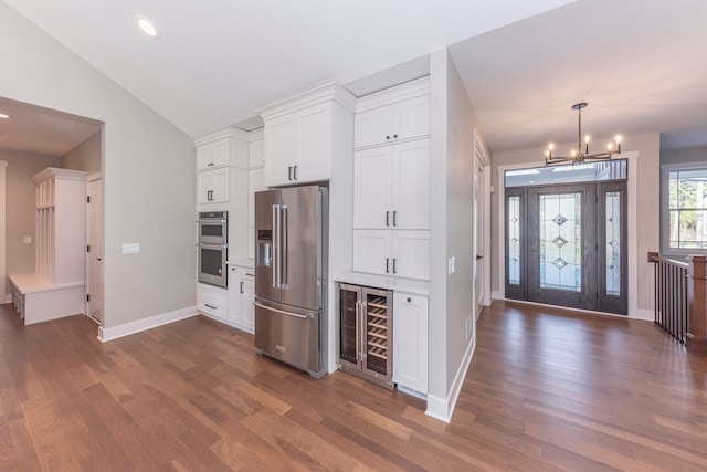 5535 W Huron River Dr, Dexter, MI 48130 - kitchen featuring appliances with stainless steel finishes, wine cooler, dark wood-type flooring, a chandelier, and white cabinetry