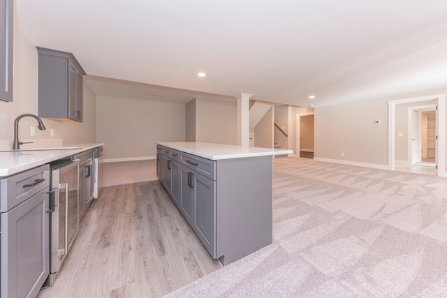 5535 W Huron River Dr, Dexter, MI 48130 - kitchen featuring gray cabinetry, a sink, light countertops, baseboards, and a kitchen island