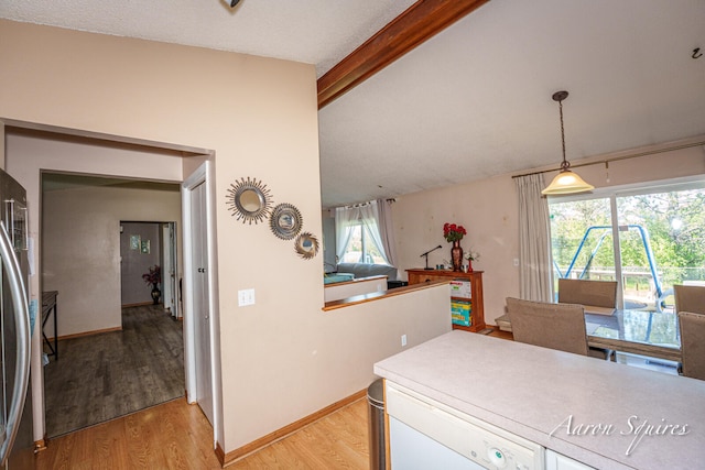 2721 Rum Creek Dr SE, Kentwood, MI 49508 - kitchen featuring light wood finished floors, stainless steel fridge, decorative light fixtures, white cabinetry, and open floor plan