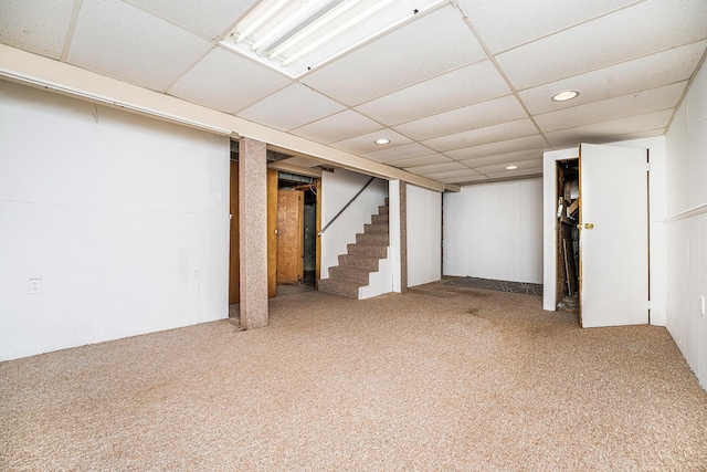 finished basement featuring carpet flooring, recessed lighting, stairway, and a paneled ceiling