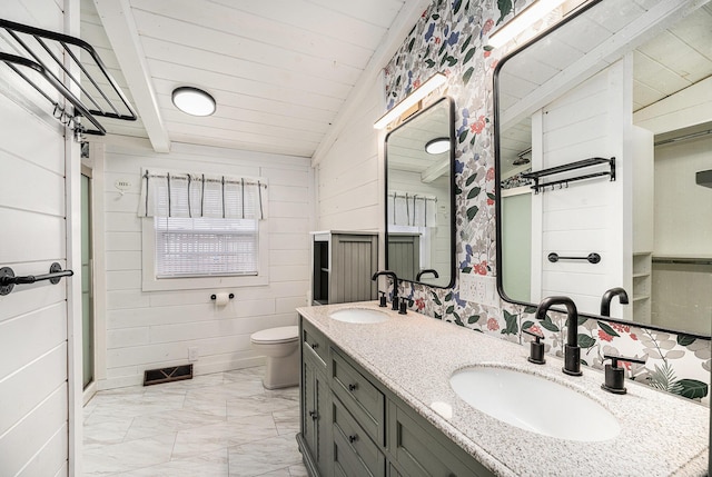 bathroom with marble look tiles, lofted ceiling, double vanity, toilet, and wood walls