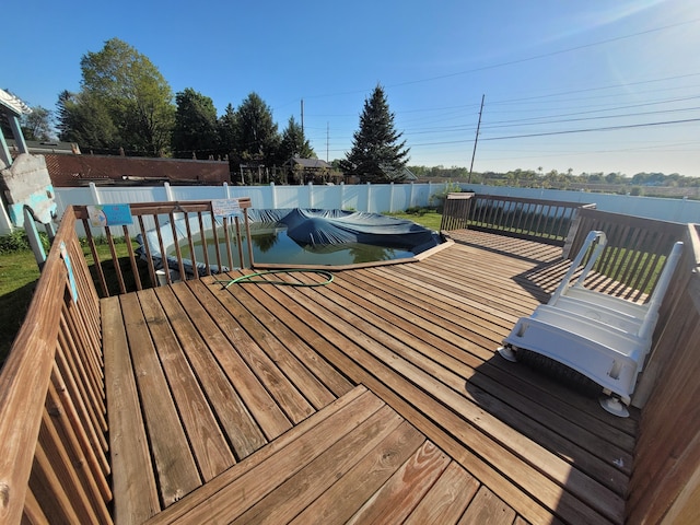 wooden terrace with a fenced backyard