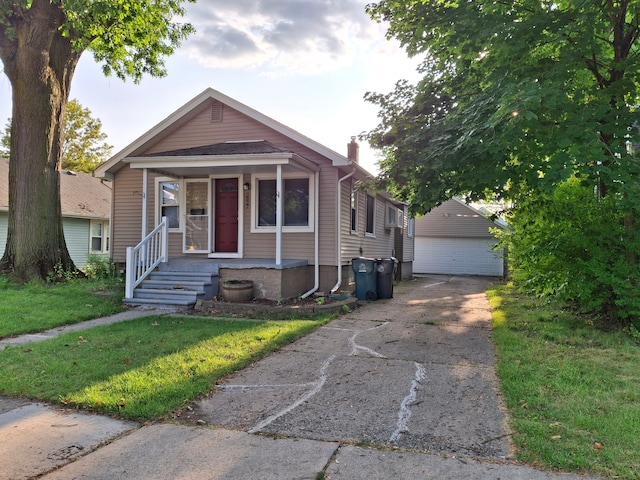 view of front facade featuring an outdoor structure, a garage, a porch, a chimney, and a front yard