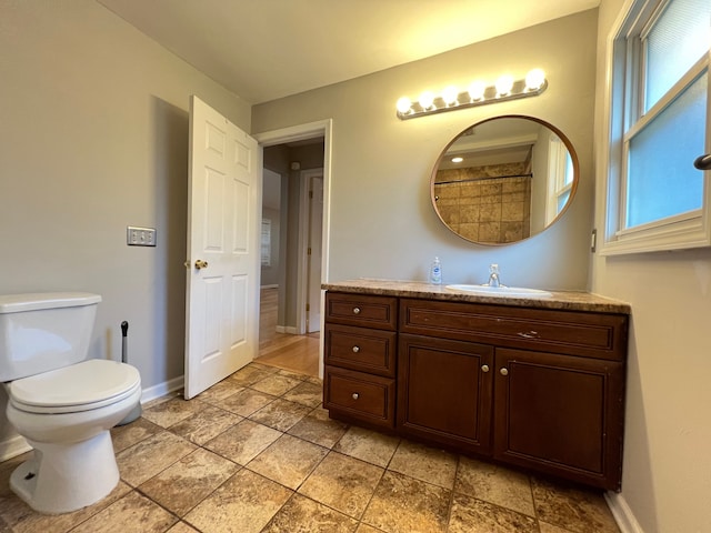 full bath featuring baseboards, toilet, vanity, and stone finish floors