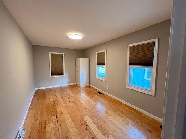spare room featuring light wood-style flooring and baseboards