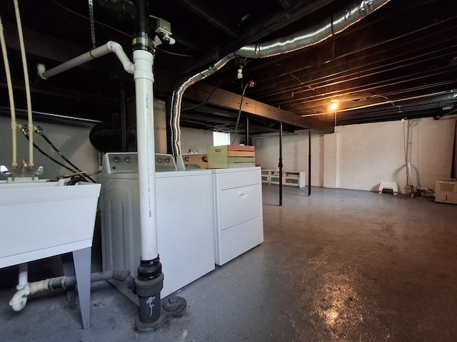 unfinished basement featuring independent washer and dryer and a sink