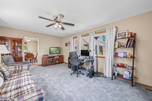 carpeted home office with a ceiling fan and baseboards