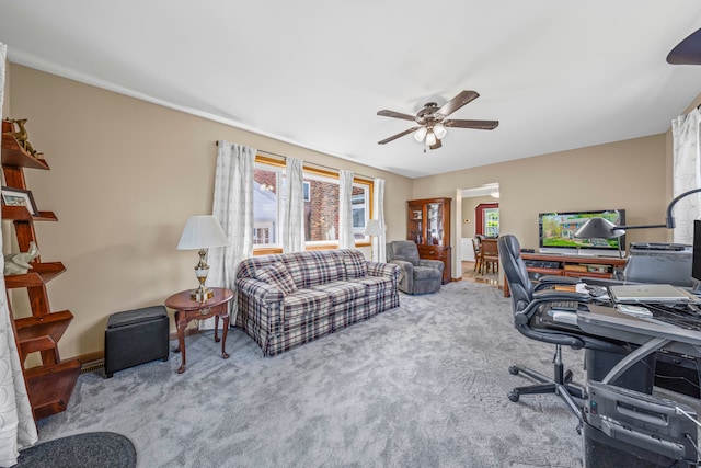 carpeted home office featuring ceiling fan