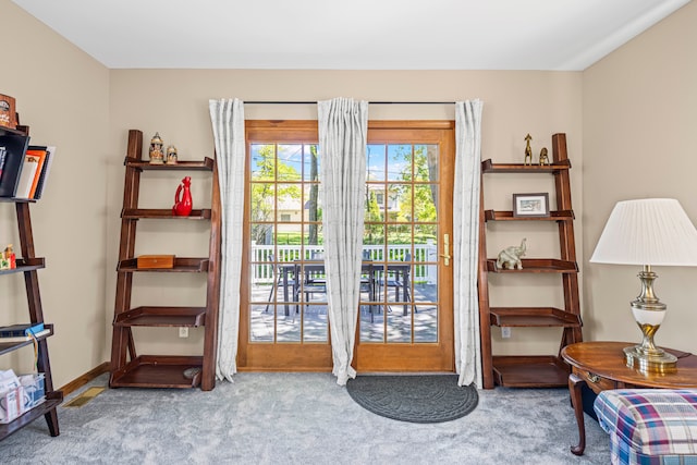 doorway with carpet flooring and baseboards