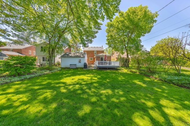 view of green lawn with a wooden deck