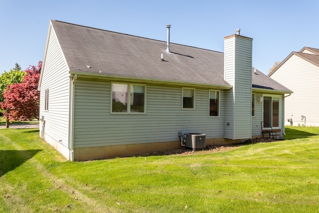 454 Woodland Dr, Saline, MI 48176 - rear view of house featuring cooling unit, a chimney, a lawn, and a shingled roof