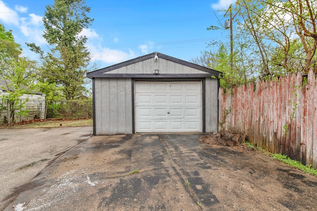 detached garage with fence and asphalt driveway