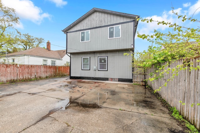 back of property with a fenced backyard and a patio area