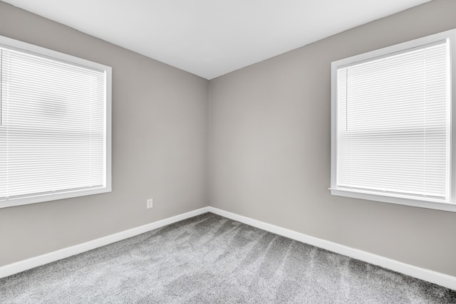 carpeted spare room with baseboards