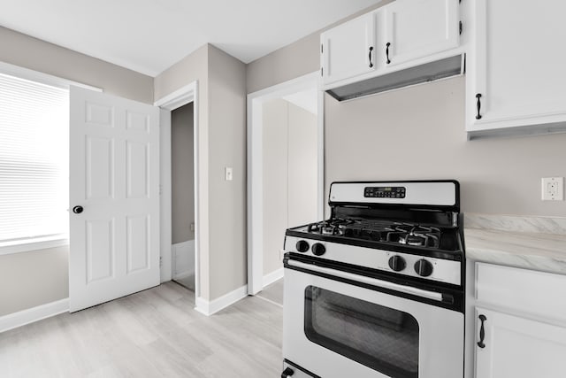 kitchen with stainless steel range with gas cooktop, white cabinets, and light wood finished floors