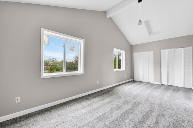 unfurnished bedroom with multiple closets, beam ceiling, baseboards, carpet floors, and high vaulted ceiling