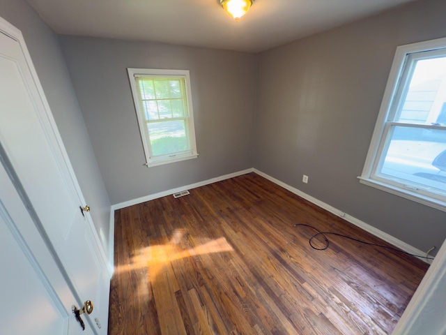unfurnished room featuring dark wood finished floors and baseboards
