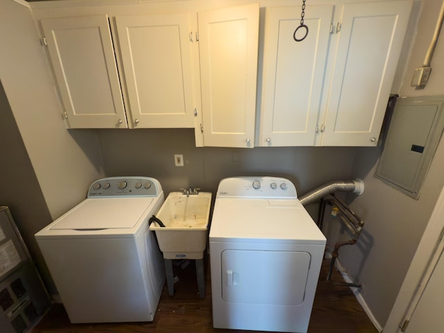 clothes washing area with independent washer and dryer, cabinet space, electric panel, and dark wood-type flooring