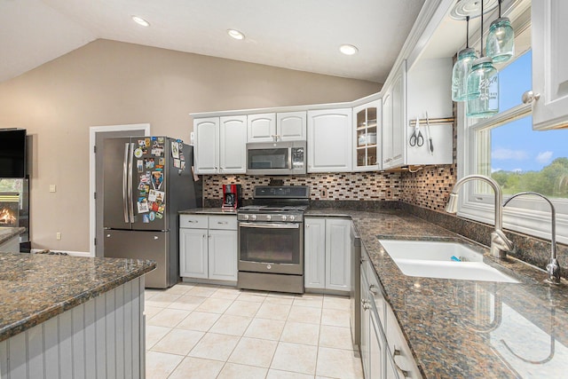 2269 W Liberty Rd, Clarklake, MI 49234 - kitchen with appliances with stainless steel finishes, a sink, vaulted ceiling, tasteful backsplash, and light tile patterned floors