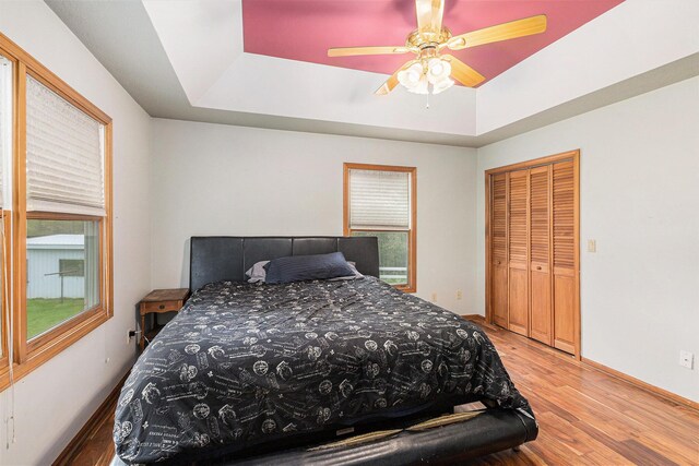 2269 W Liberty Rd, Clarklake, MI 49234 - bedroom featuring a tray ceiling, light wood-style flooring, and baseboards