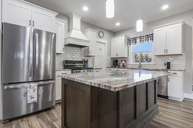 6927 Drumlin Dr, Zeeland, MI 49464 - kitchen with freestanding refrigerator, stove, premium range hood, dark wood-style flooring, and white cabinetry