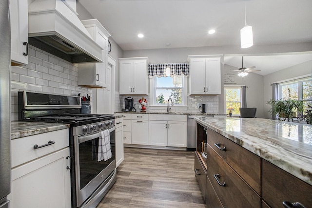 6927 Drumlin Dr, Zeeland, MI 49464 - kitchen featuring stainless steel gas range oven, a sink, custom exhaust hood, light stone countertops, and recessed lighting