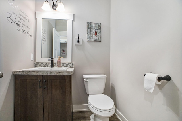 6927 Drumlin Dr, Zeeland, MI 49464 - bathroom featuring toilet, wood finished floors, vanity, and baseboards